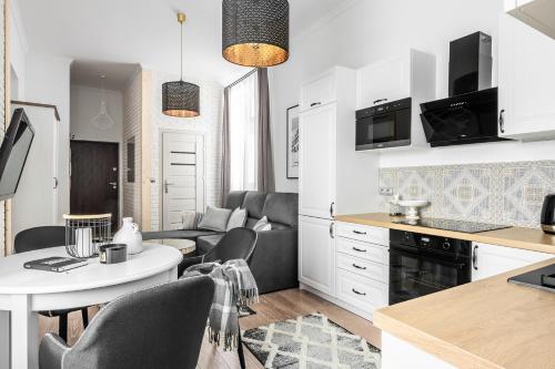 黑杜纳耶茨Apartament Biała Perła的厨房以及带桌椅的起居室。