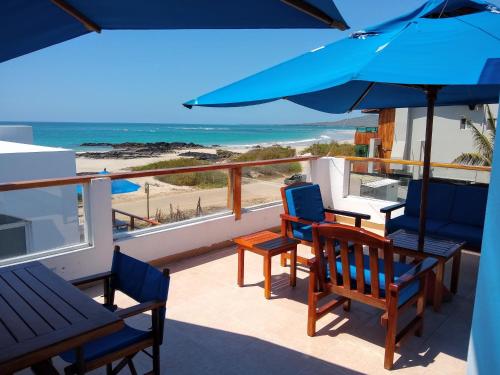 比亚米尔港德雷克住宿加早餐旅馆的一个带椅子和遮阳伞的阳台以及海滩