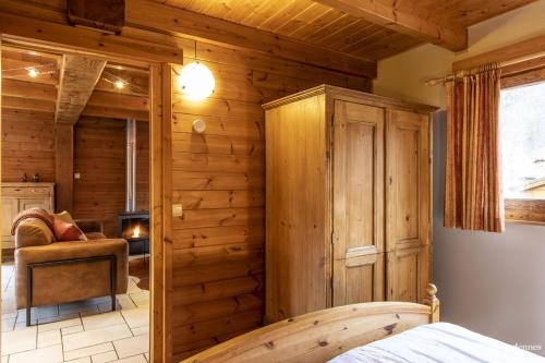 勒穆尚Chalet Val de l'Amblève的一间带木墙的卧室和一张位于客房内的床