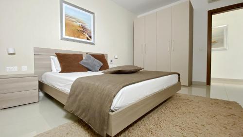 斯利马Quisisana Apartments - Cast Renting的白色卧室配有大床和地毯