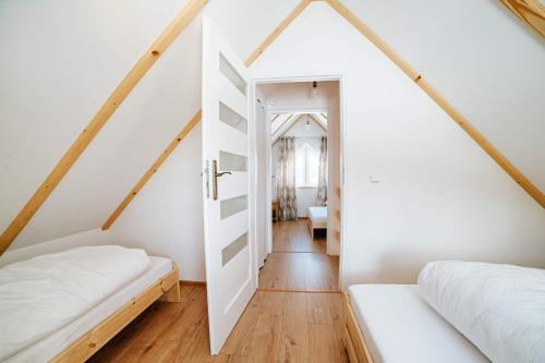 StryszawaOstoja Jaworskie的小型阁楼卧室设有两张床和梯子