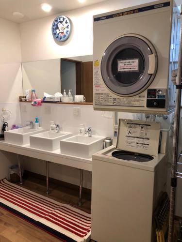 ŌdōriArt Inn 24 Sapporo的一间带两个盥洗盆和洗衣机的浴室