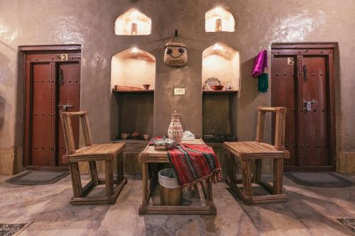 尼兹瓦Bait Al Aqr的一间房间,配有一张桌子和两把椅子
