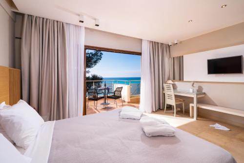 弗尔卡Olympion Sunset Halkidiki的一间卧室配有一张床和一张书桌,享有海景