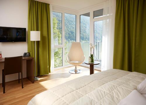 魏森乌弗魏森乌弗多瑙河文化会议酒店的一间卧室配有一张床、一张书桌和一个窗户。