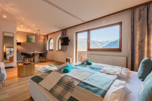 比希尔巴赫奥地利阿尔宾度假酒店的一间卧室设有一张大床和大窗户