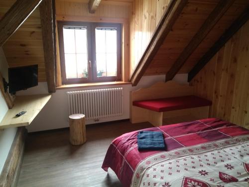 塔尔维西奥Greuth Hutte的一间卧室配有一张带红色毯子的床和窗户。