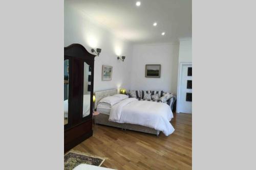 克利夫登The Loft @ Clifden Bay Apartments的一间卧室设有一张大床和一个大镜子