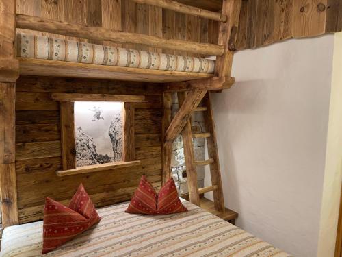 莫埃纳拉斯特原住酒店的一间卧室配有一张带红色枕头的木床
