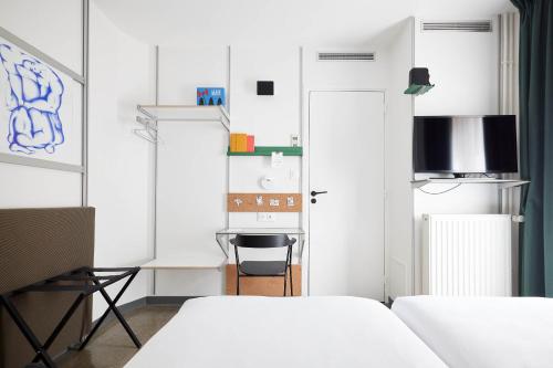 巴黎French Theory的一间小卧室,配有两张床和一张书桌