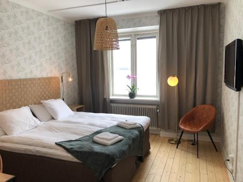 卡尔斯堡Hotell & Bistro Rödesund的卧室配有床、椅子和窗户。