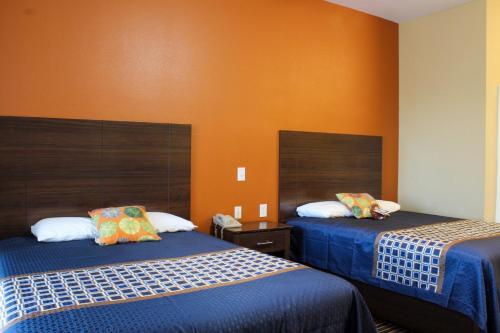 斯德伯克Bungalows Hotel & Hotel Que at Lakeline Austin Cedar Park的一间设有两张床和橙色墙壁的客房