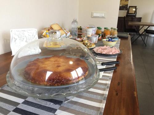 佐拉普雷多萨Braschi 8 B&B的玻璃板上的桌子和蛋糕