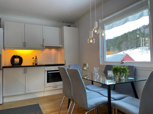 MindresundeTunold Gård - Kårhus的厨房配有桌椅和窗户。