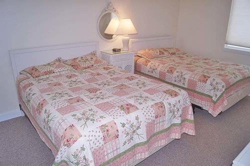 大洋城Capri 1908的一间卧室配有两张床和一盏灯。