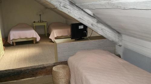 新拉巴蒂La Pastorale的客房设有两张床和一台墙上的电视。
