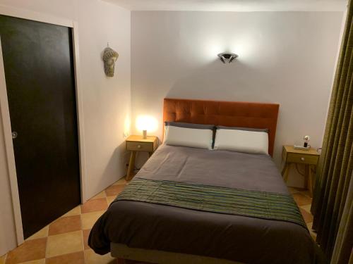 蒙彼利埃PILA & BED Montpellier Centre Corum Comédie - Chambre calme climatisée - Quiet air-conditioned room的一间卧室配有一张带两盏灯和一扇门的床。