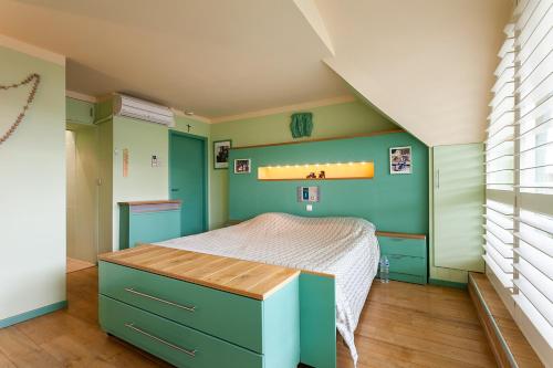 安特卫普Thai Time Wellness的一间拥有绿色墙壁的卧室,其中配有一张床