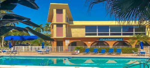 好莱坞Bposhtels Hollywood Florida的一座带游泳池的度假村,位于一座建筑前