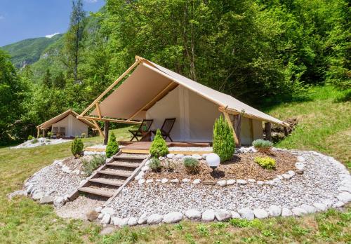 博维茨Adrenaline Check Camping的一块种有岩石和树木的田野上的帐篷