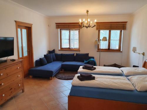 LócsLandhaus Steirerengel - Ferien & Jagd的客厅配有两张床和蓝色的沙发