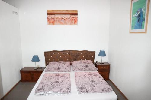 柏林罗伊度假屋的一间卧室配有一张带2个床头柜和2盏灯的床。