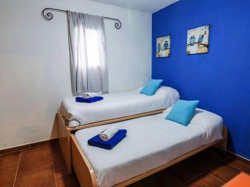 卡拉布兰卡LEIDA - Relax y privacidad的蓝色墙壁客房的两张床
