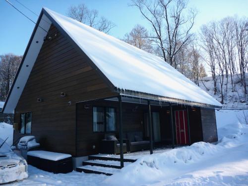 白马村ZEN CHALETS Hakuba的一座有雪盖屋顶的小建筑