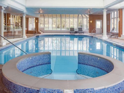 阿克灵顿杜肯哈尔夫布莱克本Spa美居酒店的大楼里一个蓝色的大泳池