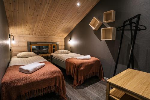 列维Levi Black Apartments的客房设有两张床和木制天花板。