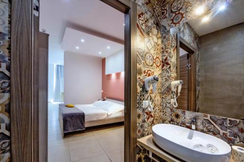 拉古萨San Giorgio Palace Hotel Ragusa Ibla的一间带水槽的浴室和一张位于客房内的床