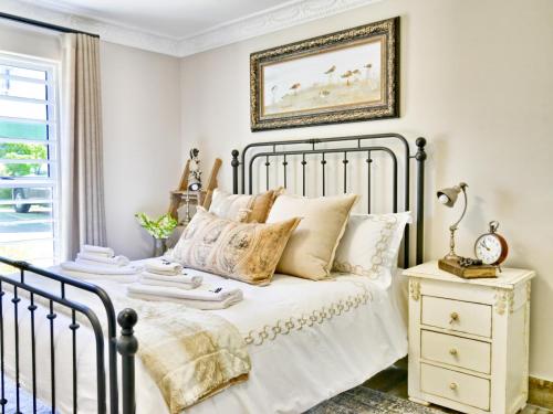 豪特湾dk villas 4 Riverview, Hout Bay的一间卧室配有带白色床单和枕头的床。