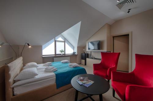 LesnikiHotel Riders Equides club的一间卧室配有一张床和两张红色椅子