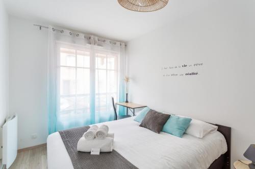 圣马洛L'Echo des Vagues的白色卧室,配有带毛巾的床