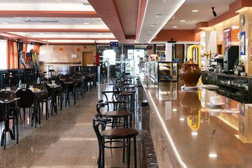 San Román安达穆圣罗曼酒店的餐厅在柜台处设有酒吧凳子