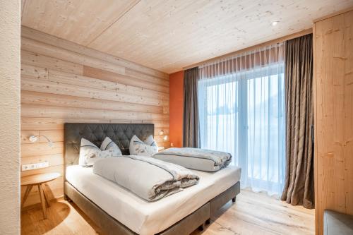 沃瑟姆阿尔伯格Naturhaus am Arlberg的带大窗户的客房内的两张床