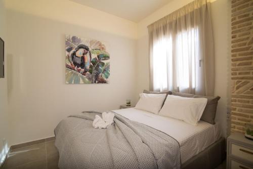 扎金索斯镇Lodge Apartments的卧室配有一张床,墙上挂有绘画作品