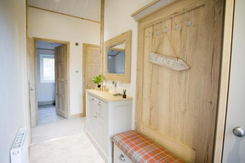 基督城6 berth luxury lodge in Christchurch Dorset的一间带水槽和镜子的浴室