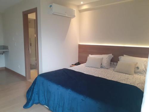佩德拉阿祖尔Vista Azul的一间卧室配有一张大床,提供蓝色的床单和枕头