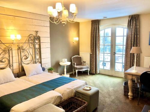 迪森Hotel & Restaurant - Auberge De Hilver的酒店客房设有一张大床和一张书桌。