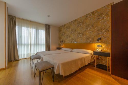 拉赫拉克瑟海滩酒店的酒店客房设有一张大床和石墙