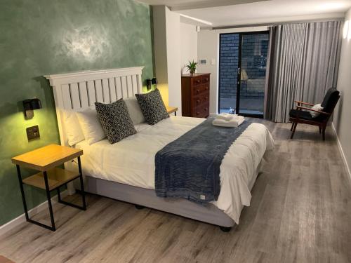 东伦敦Coral Wood Self Catering Suites and B&B的卧室配有1张床、1张桌子和1把椅子
