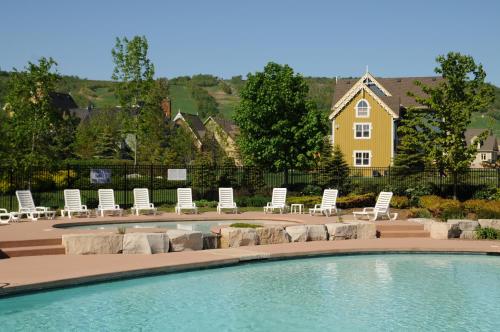 蓝山Blue Mountain Resort Home Collection的一个带躺椅的游泳池和一个背景房子