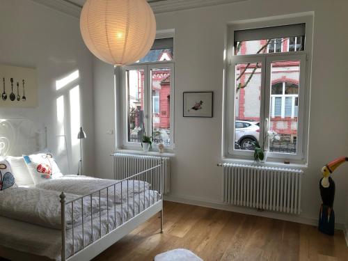 兰施泰因L11 Ferienwohnung的白色的客房设有一张婴儿床和两个窗户。