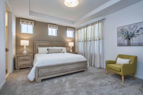 奥兰多5 Bedrooms Townhome w- Splashpool - 8205SA的一间卧室配有一张床和一把绿色椅子