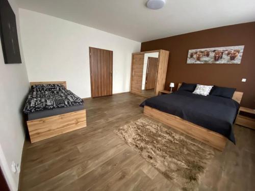 比尔森Apartmány Černý Tulipán 3的一间卧室设有两张床,铺有木地板