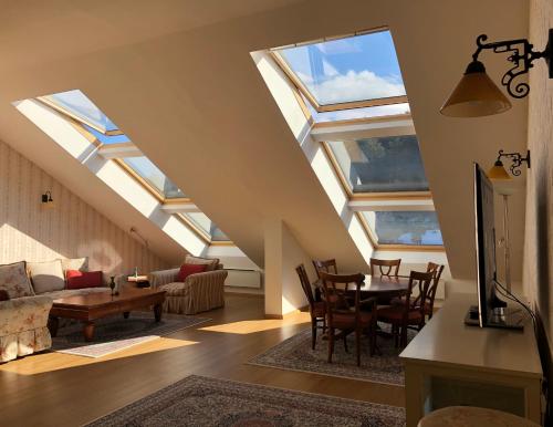 班斯科LUXURY PENTHOUSE WITH A LAVISH SPA and 2 en-suite bedrooms的客厅设有天窗天花板和桌椅