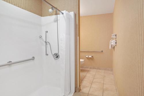 查尔斯顿Microtel Inn & Suites by Wyndham Charleston的带淋浴的浴室和玻璃门
