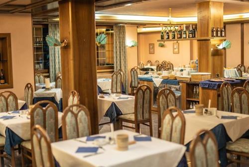 平佐洛Hotel Quadrifoglio的一间配备有桌椅及蓝餐巾的用餐室