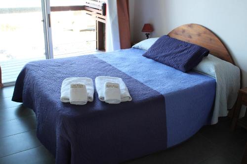 德尔迪阿布罗角Koe Porá的一间卧室配有蓝色的床和拖鞋